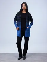 Cárdigan tejido largo marca Ninety, color beige con rayas horizontales negras. Tiene bolsillos delanteros y está confeccionado en acrílico, poliéster y elastano.