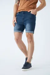 Bermuda de jean azul con lavado clásico, diseño de cinco bolsillos, cierre de cremallera y botón, con detalle de botamanga doblada.