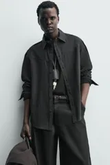 Camisa de corte regular confeccionada en tejido fluido con mezcla de lyocell, cuello solapa, manga larga con puños abotonados y cierre frontal de botones.