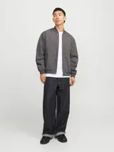Campera bomber liviana color gris oscuro, con cierre frontal de cremallera, cuello baseball, bolsillos funcionales y puños elásticos acanalados.