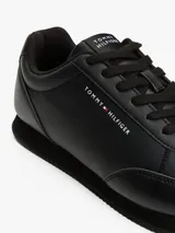 Zapatillas Tommy Hilfiger de cuero sintético negro, con logo en el lateral y suela de goma.