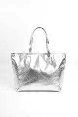 Bolso tipo tote color plateado metalizado, con doble asa de hombro y diseño amplio.