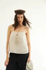 Top de lino color beige, de escote recto y breteles finos, con calce holgado.
