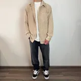 Sobrecamisa de pana negra con cuello clásico, cierre abotonado, manga larga con puños abotonados, bolsillo de parche en el pecho y corte recto. 