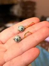 Aros colgantes dorados con piedra natural jaspe dálmata en forma de esfera.