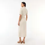 Vestido camisero largo color beige, de manga corta, con cuello solapa, cierre frontal de botones y lazo ajustable en la cintura.