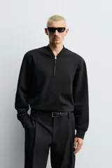 Sudadera de corte regular fit confeccionada en tejido de algodón con interior de rizo. Presenta cuello tipo rib, cierre frontal de cremallera y acabados en rib en puños y bajo.