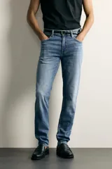 Jeans slim fit de color negro para hombre, con tiro medio, diseño de cinco bolsillos y cierre frontal con cremallera y botón.