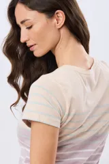 Remera de manga corta y cuello redondo, confeccionada en algodón con diseño de rayas horizontales en tono beige, rosado y azul marino.