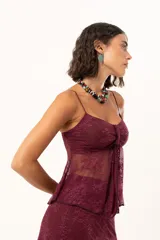 Top de encaje color bordó con breteles finos, diseño con nudo frontal y transparencia.