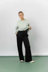 Pantalón blanco de silueta amplia y caída fluida, con cintura alta elastizada y lazo regulable con terminaciones metálicas.