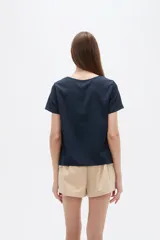 Blusa de viscosa color natural, con cuello a la base, manga corta y detalle de plisado cruzado en el frente. Presenta un corte holgado.