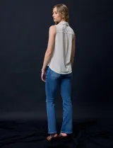 Blusa color crema sin mangas, con cuello camisero, cierre frontal con botones y bolsillo de crochet.