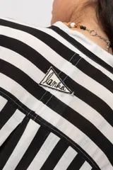 Camisa de rayas blanco y negro, de corte oversize y mangas cortas holgadas.