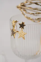 Aros colgantes dorados con forma de estrella, decorados con circonitas.