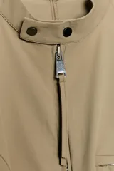 Mono corto entallado de cuello redondo y manga sisa, con cierre frontal de cremallera metálica y bolsillos delanteros con cremallera.