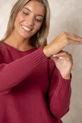 Buzo de corte relajado y cuello redondo, con detalles de costura vertical en la parte inferior y puños acanalados en las mangas.