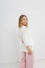 Sweater oversize de tejido liviano color blanco roto, con textura semi traslúcida, escote redondo y mangas amplias estilo murciélago.