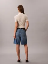 Shorts tipo bermuda de corte relajado y talle alto, confeccionados en una mezcla de algodón y lino. Presentan un diseño clásico de cinco bolsillos, cierre con cremallera y botón, y pespuntes decorativos.