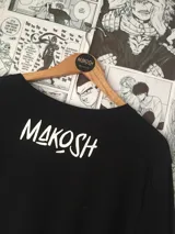 Remera negra con estampado del Maestro Roshi con detalles en rojo y texto en japonés.