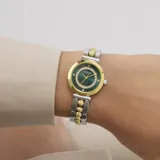 Reloj analógico Guess modelo Leena con caja de 27 mm en tono dorado y esfera verde decorada con cristales. Presenta una malla de acero inoxidable bicolor en tonos plateado y dorado.