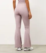 Pantalón deportivo Get Over modelo flare, confeccionado en microfibra acanalada de color lila. Presenta un corte ajustado en caderas y muslos con apertura acampanada desde la rodilla.