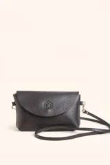 Cartera bandolera de cuero negro con solapa frontal, cierre principal y detalle de logo grabado en el centro. Incluye correa larga ajustable y extraíble.
