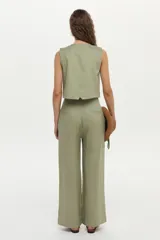Pantalón de lino color beige, de corte ancho y relajado, con cintura alta y bolsillos laterales.