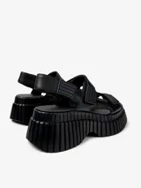 Sandalias negras con plataforma gruesa y tiras ajustables con velcro.