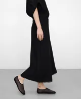 Pantalón culotte negro de lino y viscosa, con trabillas en la cintura, bolsillos laterales, bolsillos de plastrón en la espalda y bajo desflecado.