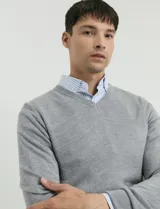 Sweater de punto con escote en V y manga larga, con puños y ruedo acanalados.