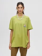 Remera de corte cuadrado y ajuste holgado, color verde oliva, con pequeño estampado gráfico de un velero en el pecho y etiqueta decorativa en la manga.