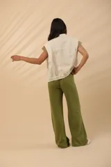 Chaleco color crudo con cuello camisero, abotonado al frente y bolsillos de parche.