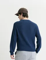 Sweater de punto inglés con escote redondo y mangas largas. Presenta cuello y puños terminados en punto canalé.