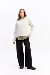 Canguro de algodón color beige con capucha amplia y corte relajado. Presenta un estampado rectangular en la espalda con motivos florales en tonos azules y el texto 'Harmony of Bloom'.