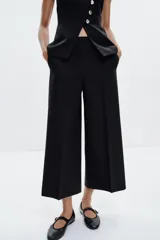 Pantalón culotte de tiro alto con pernera ancha y corta. Presenta bolsillos delanteros y cierre lateral con cremallera oculta.