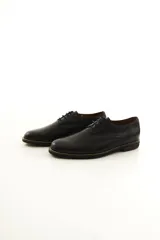 Zapato de vestir acordonado para hombre, confeccionado en 100% cuero vacuno negro con diseño clásico, punta redonda y suela con detalle de costura visible.