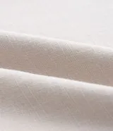 Pantalón recto de sarga en color crudo, diseñado para talles grandes (Curve & Plus Size). Presenta bolsillos laterales tipo cuchillo, cierre frontal con botones a la vista y un cinturón del mismo tejido con hebilla de efecto carey.