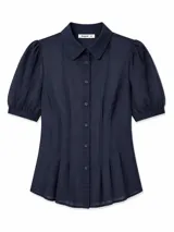 Vestido corto azul marino con cuello camisero, cierre frontal con botones y mangas cortas abullonadas con puños elastizados. Presenta pinzas frontales que aportan volumen y estructura a la falda.