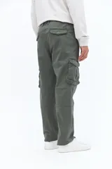 Pantalón cargo color verde militar con bolsillos laterales tipo cargo, bolsillos traseros con solapa y pasacintos. Diseño de corte recto sin puños en los tobillos.