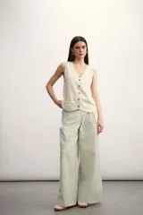 Chaleco de lino color verde oscuro, con escote en V, cierre frontal con botones y corte recto.