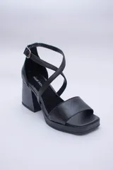 Sandalias de cuero color cobre con plataforma y taco cuadrado. Tiras cruzadas sobre el empeine y pulsera con hebilla al tobillo.