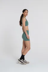 Minifalda deportiva color verde azulado, confeccionada en tejido Activelu con compresión media, cintura alta y protección UV50+.