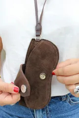 Cuelga lentes de cuero rojo con correa fina y botón metálico.