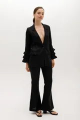 Blazer color beige confeccionado en lino, con cuello solapa, cierre frontal con un botón y mangas largas con volantes en capas.