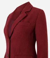 Abrigo largo de corte slim, color gris con textura jaspeada. Presenta solapas clásicas, cierre frontal con botones, bolsillos laterales con solapa y abertura trasera. Incluye forro interno.