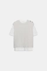 Top de cuello redondo y manga corta con diseño de capas que combina una remera de algodón blanca con un chaleco de punto gris superpuesto. Presenta detalles de botones joya en el hombro.