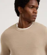 Suéter de punto para hombre, color celeste, con textura acanalada horizontal, cuello redondo y mangas largas con puños ajustados.