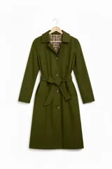 Trench reversible de corte largo, con un lado en color tostado liso y el otro lado con estampado de cuadros. Presenta cuello solapa, cierre frontal de botones, bolsillos laterales y puños con detalle de estampado a cuadros.