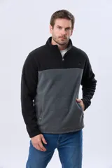 Buzo de polar bicolor azul marino y verde con medio cierre y bolsillos laterales con cierre.
